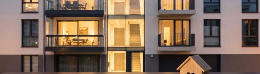Immobilien als Kapitalanlage – Hausmodell, Münzstapel und Wachstumskurve vor modernem Wohngebäude